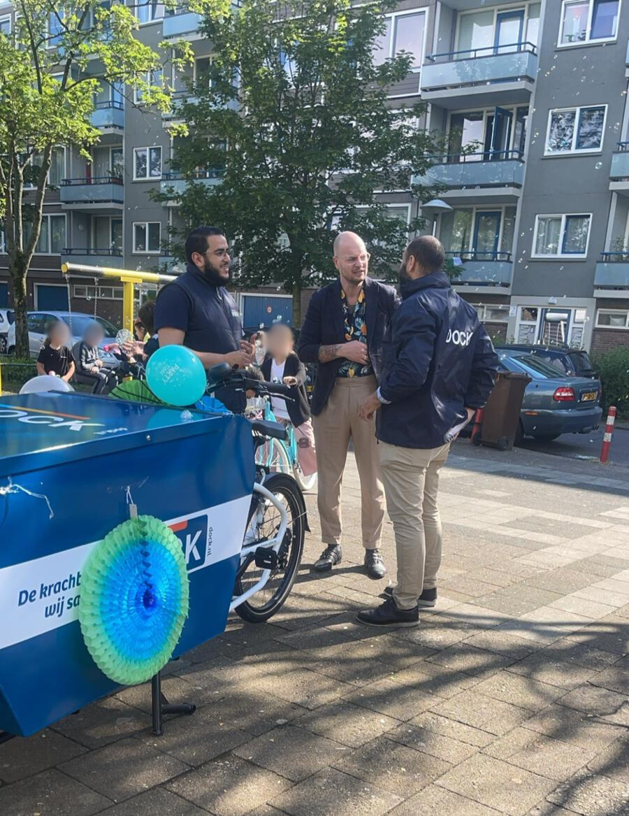 Wethouder de Vries in gesprek met medewerkers van Dock.
